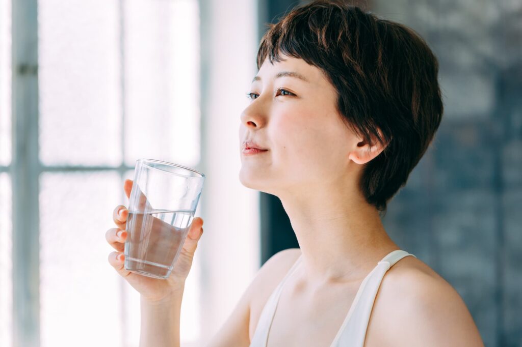 コップの水を飲む女性