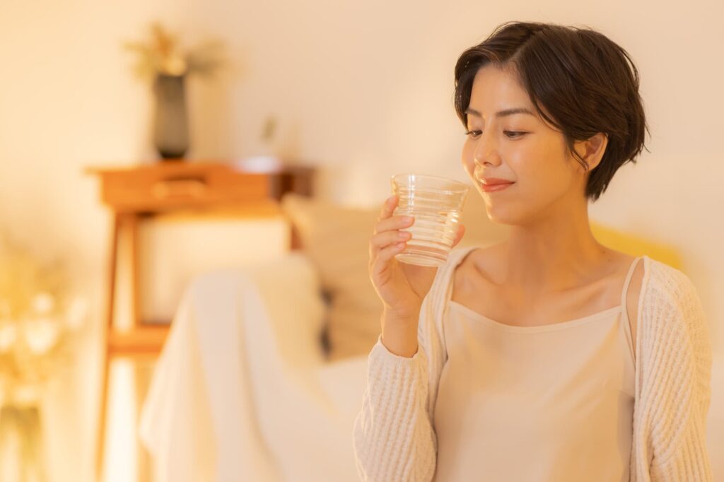 部屋で水を飲む女性